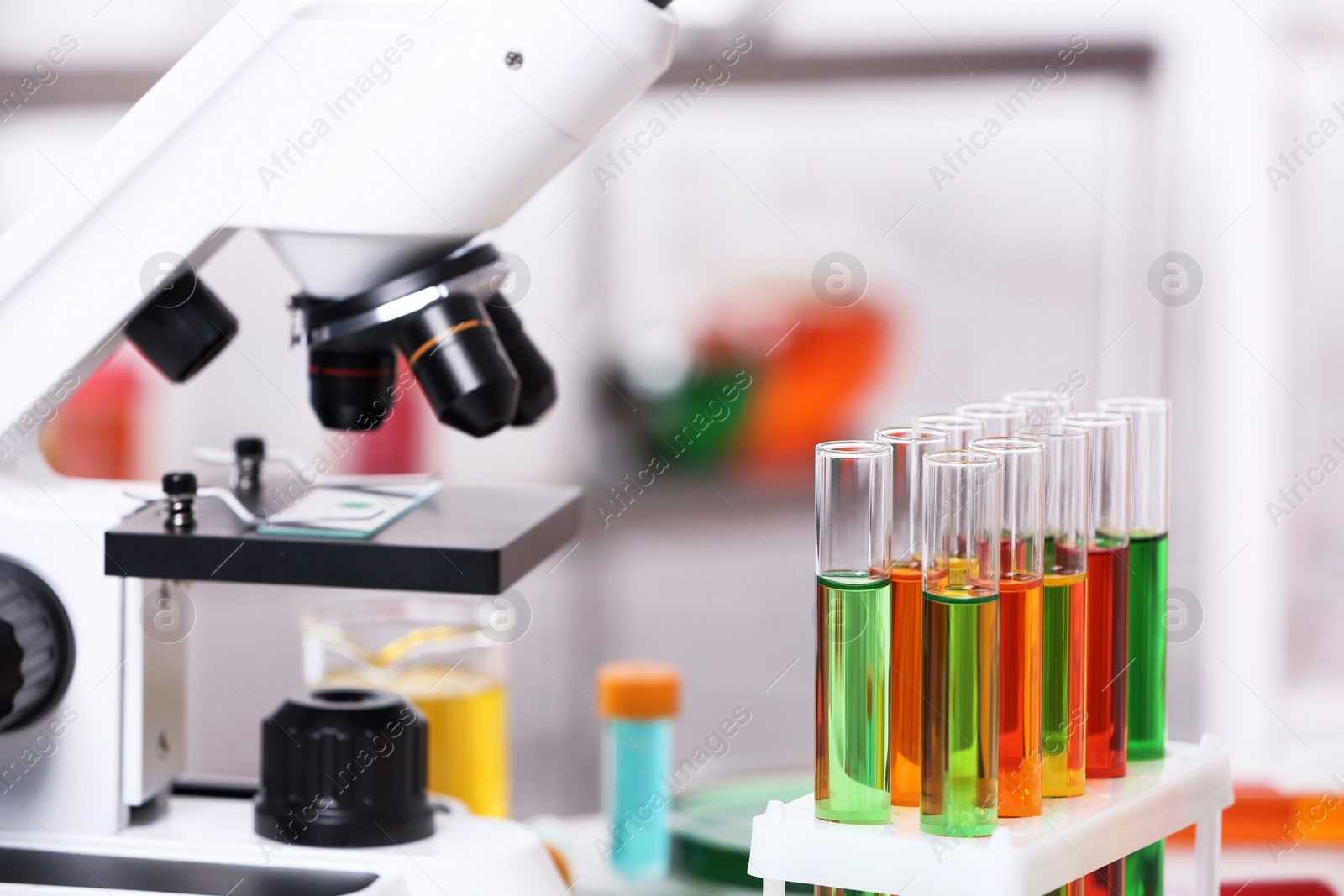 Photo of Test tubes with samples and microscope in chemistry laboratory