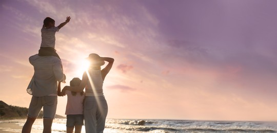 Image of Family on sandy beach near sea at sunset, space for text. Banner design