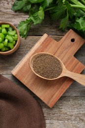 Photo of Spoon of celery seeds and fresh plant on wooden table, flat lay