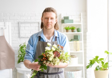 Male florist with beautiful bouquet at workplace