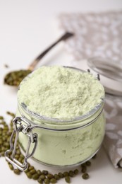 Photo of Glass jar of flour and mung beans on white table