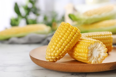 Photo of Plate with tasty sweet corn cob on table