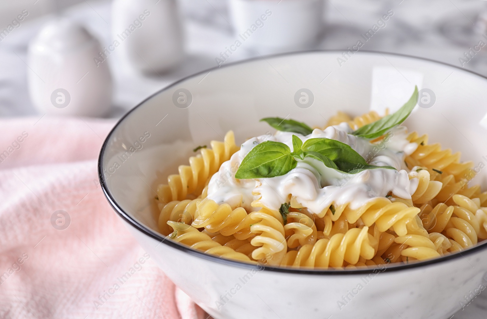Photo of Delicious pasta with sauce and basil on table, closeup view