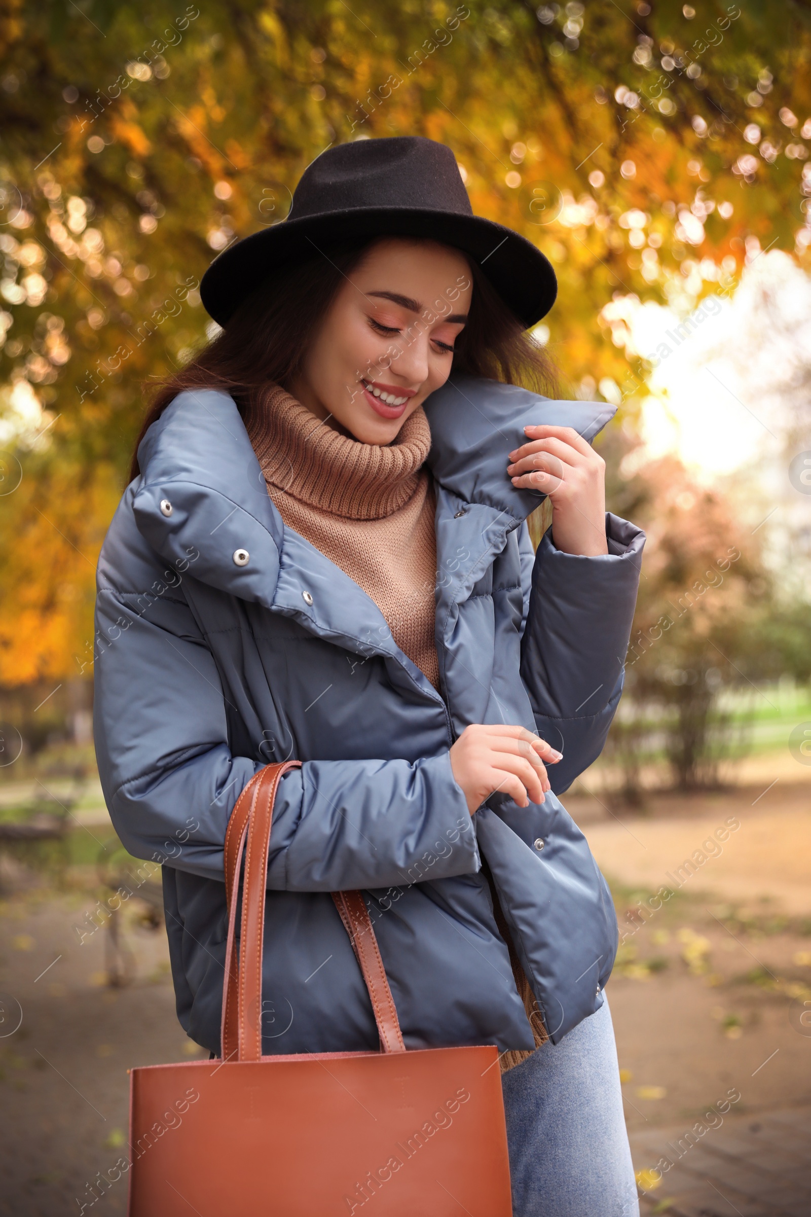 Photo of Young woman wearing stylish clothes in autumn park