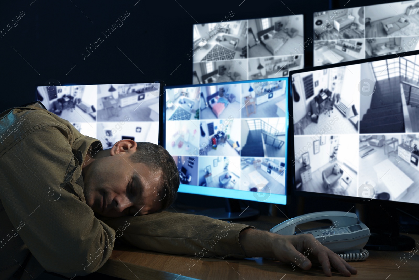 Photo of Tired security guard sleeping in office at night