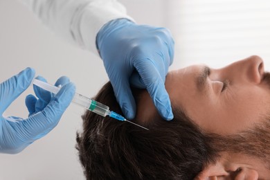 Photo of Trichologist giving injection to patient in clinic, closeup