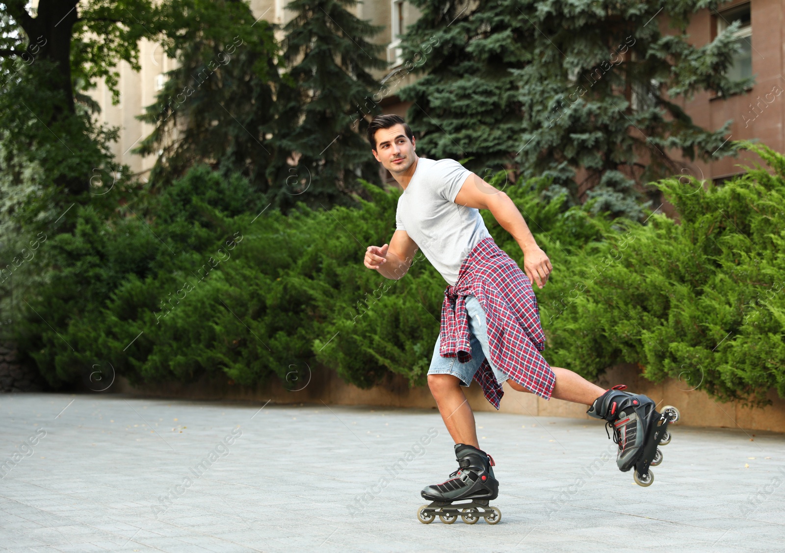 Photo of Handsome young man roller skating outdoors. Recreational activity