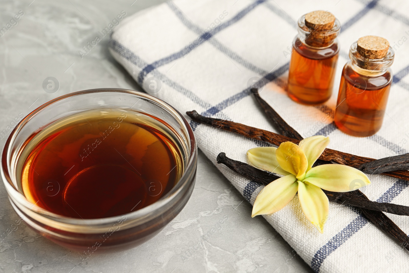 Photo of Aromatic homemade vanilla extract on light grey marble table