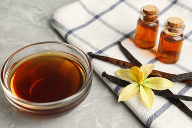 Aromatic homemade vanilla extract on light grey marble table