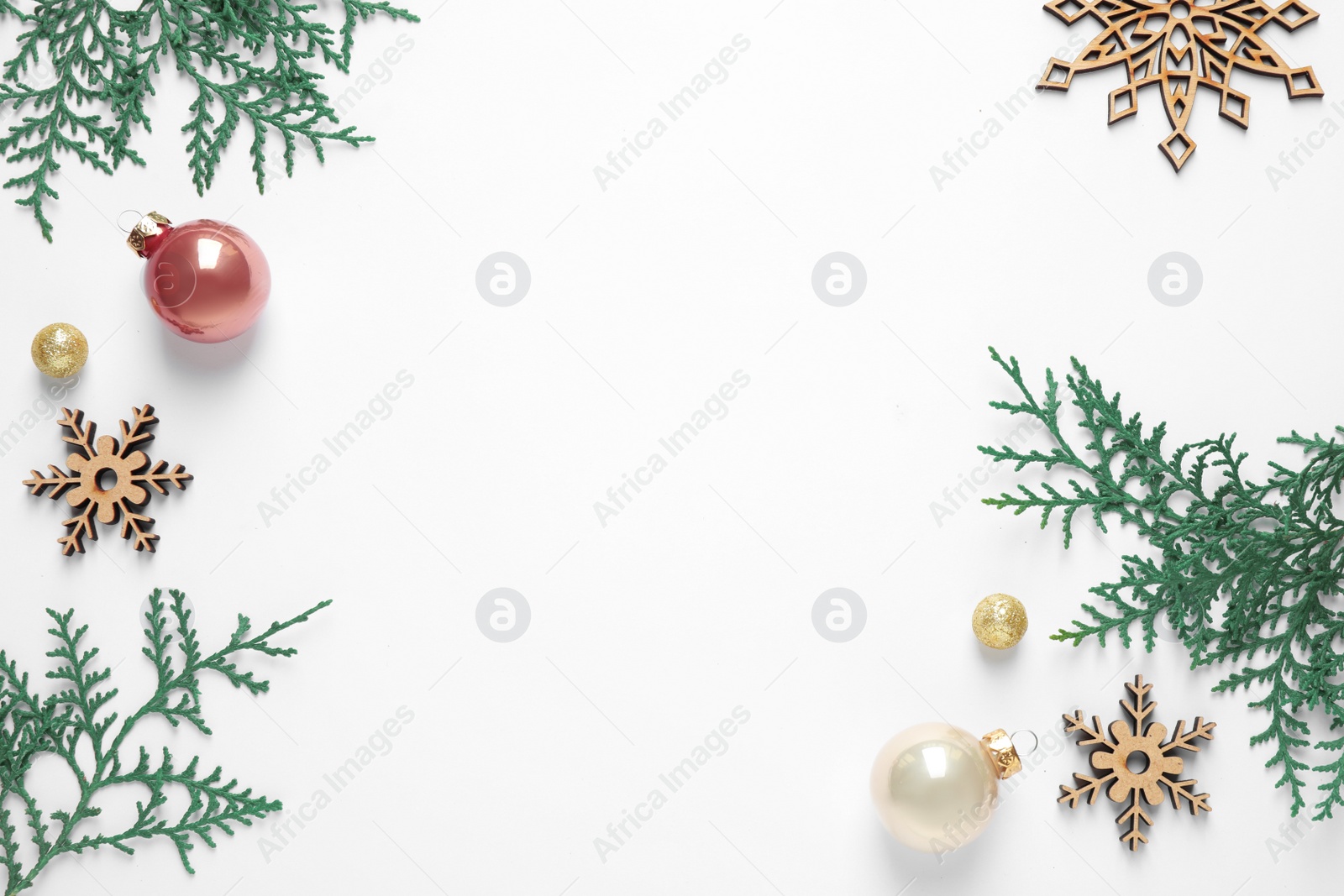 Photo of Flat lay composition with Christmas tree branches and festive decor on white background. Space for text