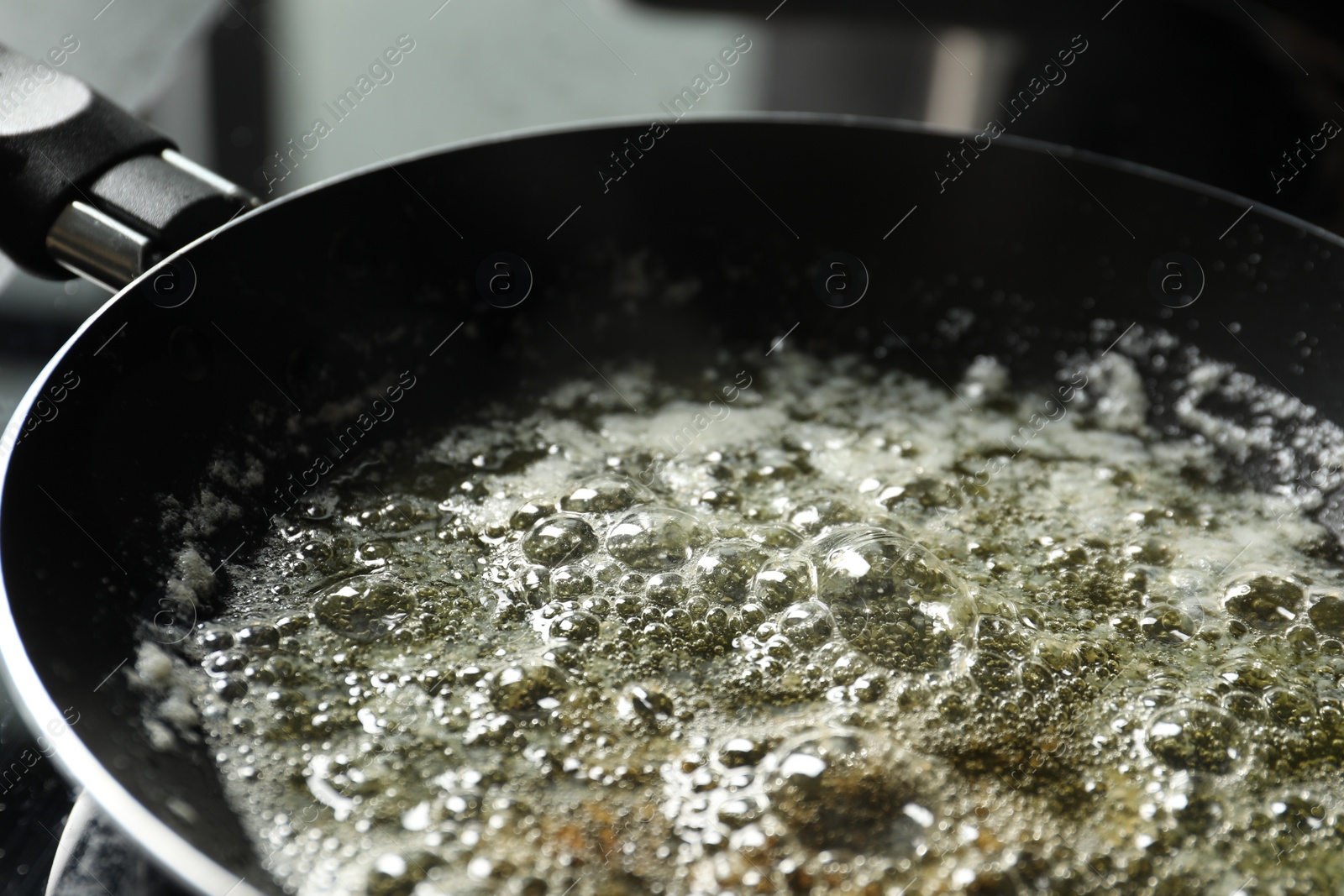 Photo of Melting butter in frying pan on table, closeup