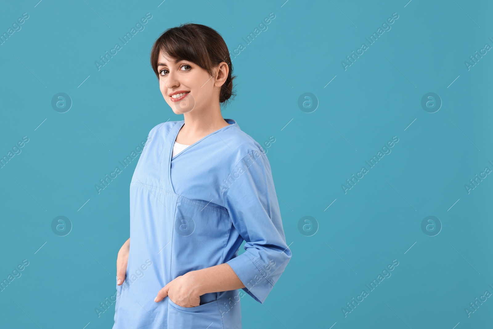 Photo of Portrait of smiling medical assistant on light blue background. Space for text