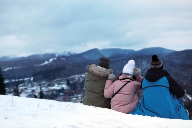 Friends enjoying mountain landscape, space for text. Winter vacation