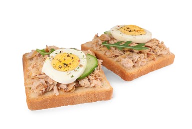 Photo of Delicious sandwiches with tuna, greens, cucumber, boiled egg and spices on white background