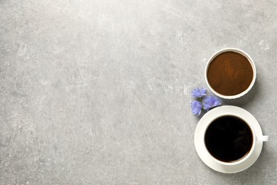 Photo of Cup of delicious chicory drink, powder and flowers on light grey table, flat lay. Space for text