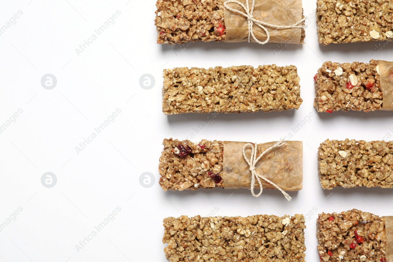 Photo of Different tasty granola bars on white background, flat lay. Space for text
