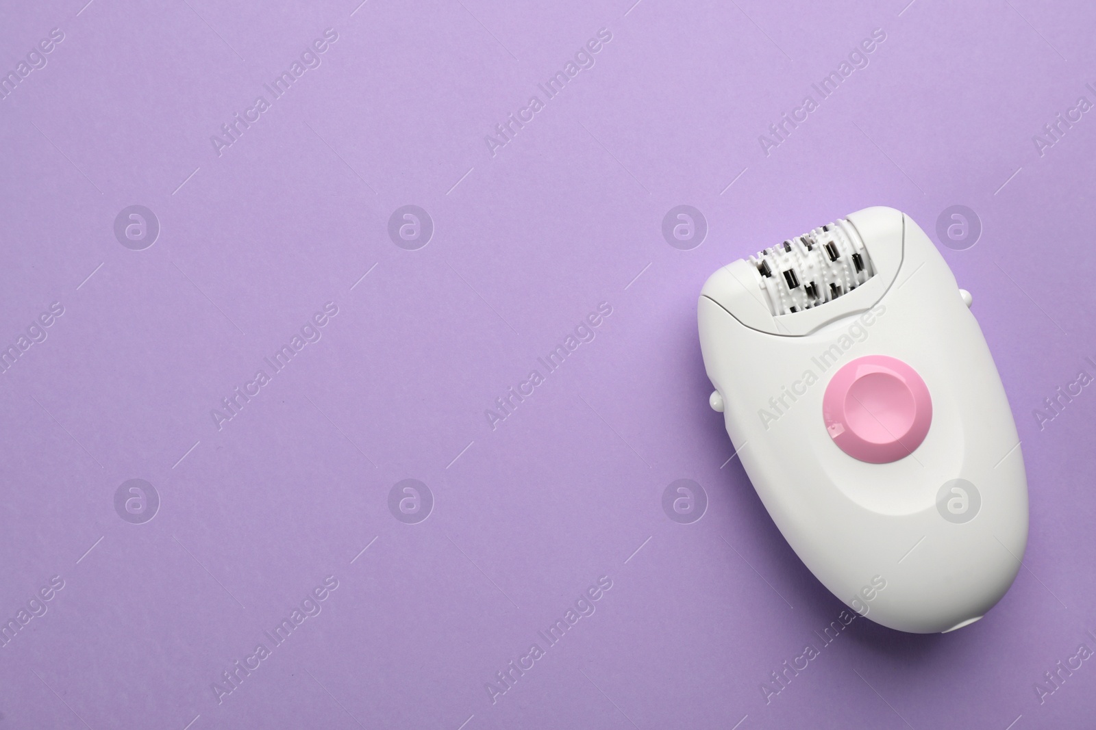 Photo of Modern epilator on lilac background, top view. Space for text