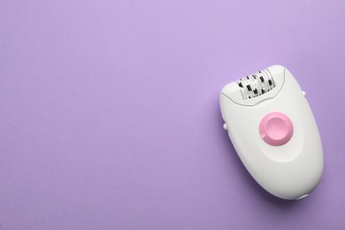 Modern epilator on lilac background, top view. Space for text
