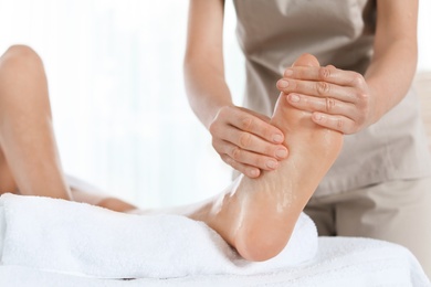 Woman receiving foot massage in wellness center, closeup