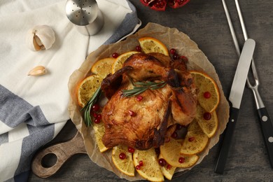 Photo of Baked chicken with orange slices on grey table, flat lay