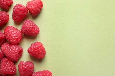 Photo of Fresh sweet ripe raspberries on light green background, flat lay. Space for text