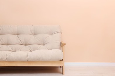 Photo of Comfortable sofa near beige wall indoors. Space for text