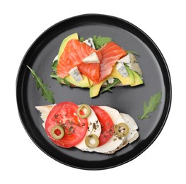 Plate with different tasty bruschettas on white background, top view