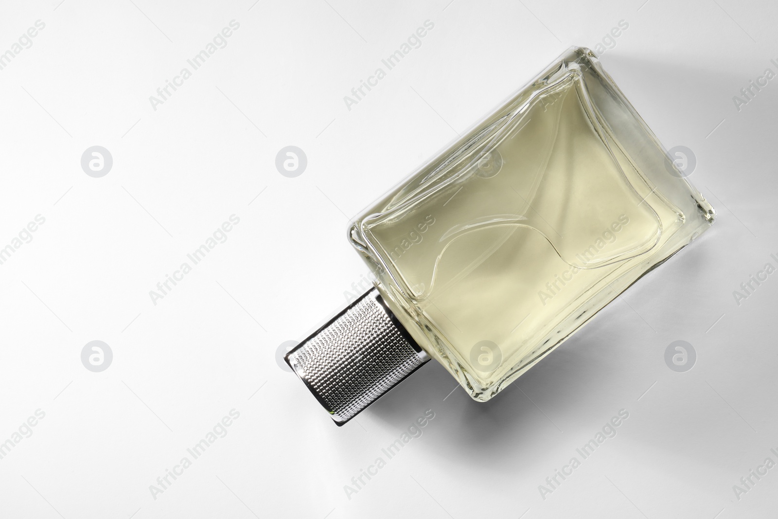 Photo of Luxury men`s perfume in bottle on white background, top view. Space for text