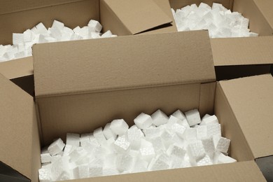 Photo of Many open cardboard boxes with piecespolystyrene foam