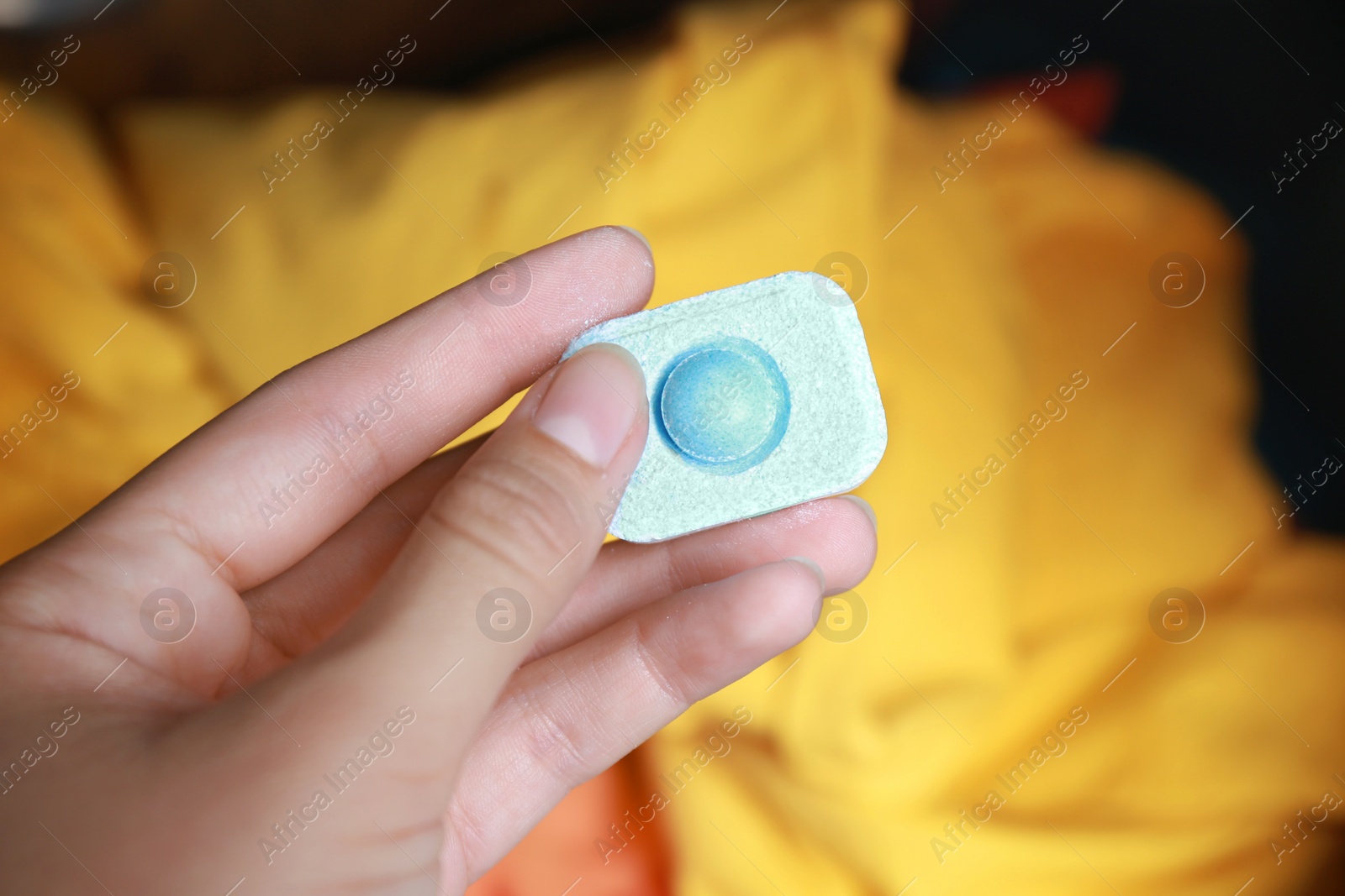 Photo of Woman putting water softener tablet into washing machine, closeup