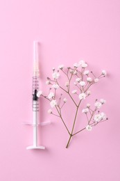 Photo of Cosmetology. Medical syringe and gypsophila on pink background, top view