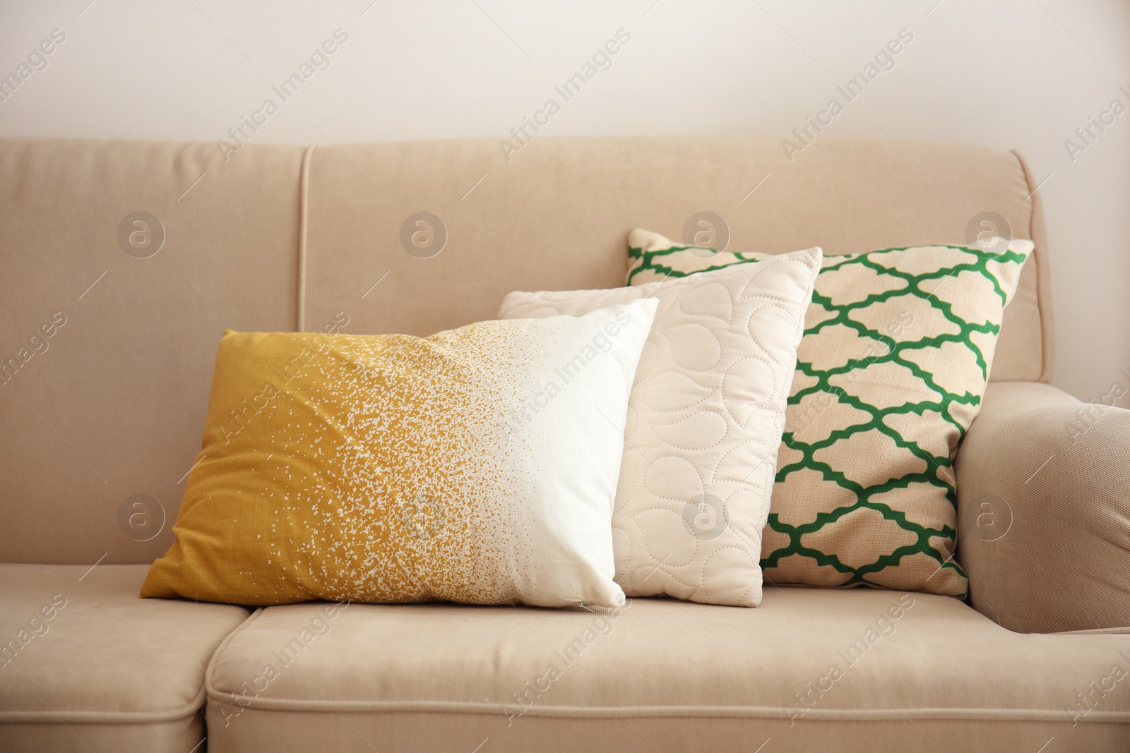 Photo of Different soft pillows on sofa in room