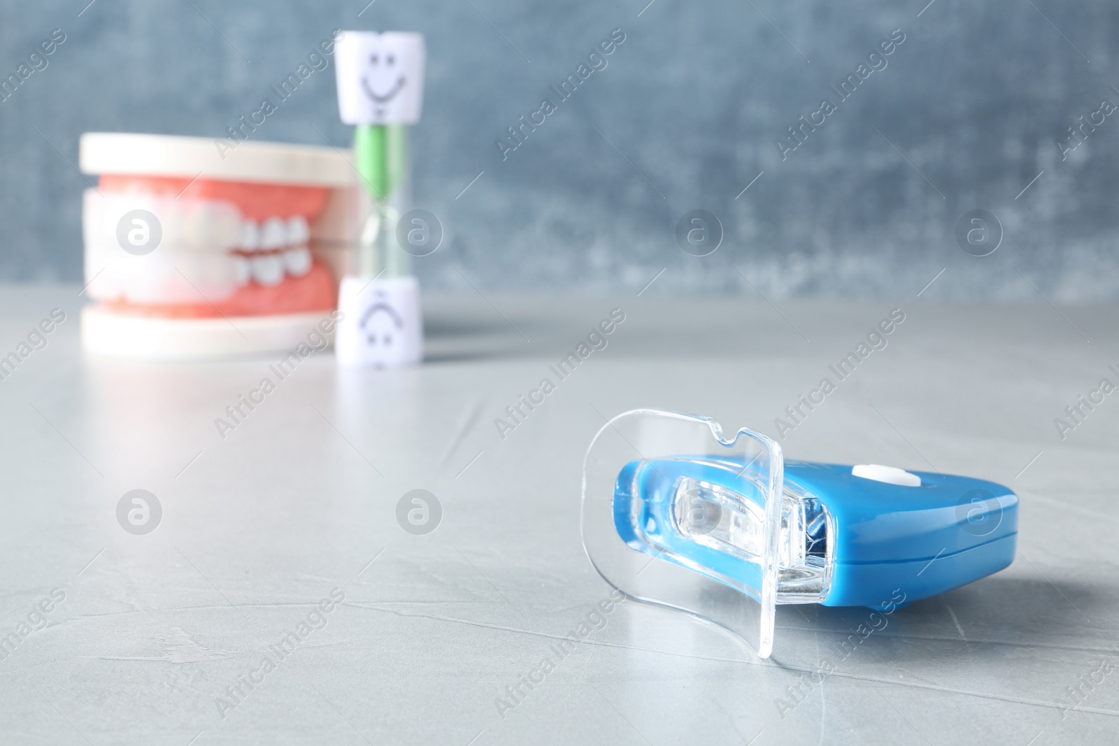 Photo of Teeth whitener on table against blurred background. Space for text