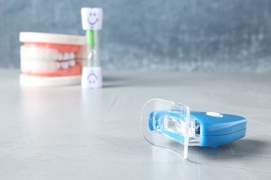 Teeth whitener on table against blurred background. Space for text