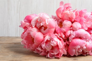 Bunch of beautiful pink peonies on wooden table, closeup