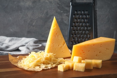 Photo of Grated and cut delicious cheese on board