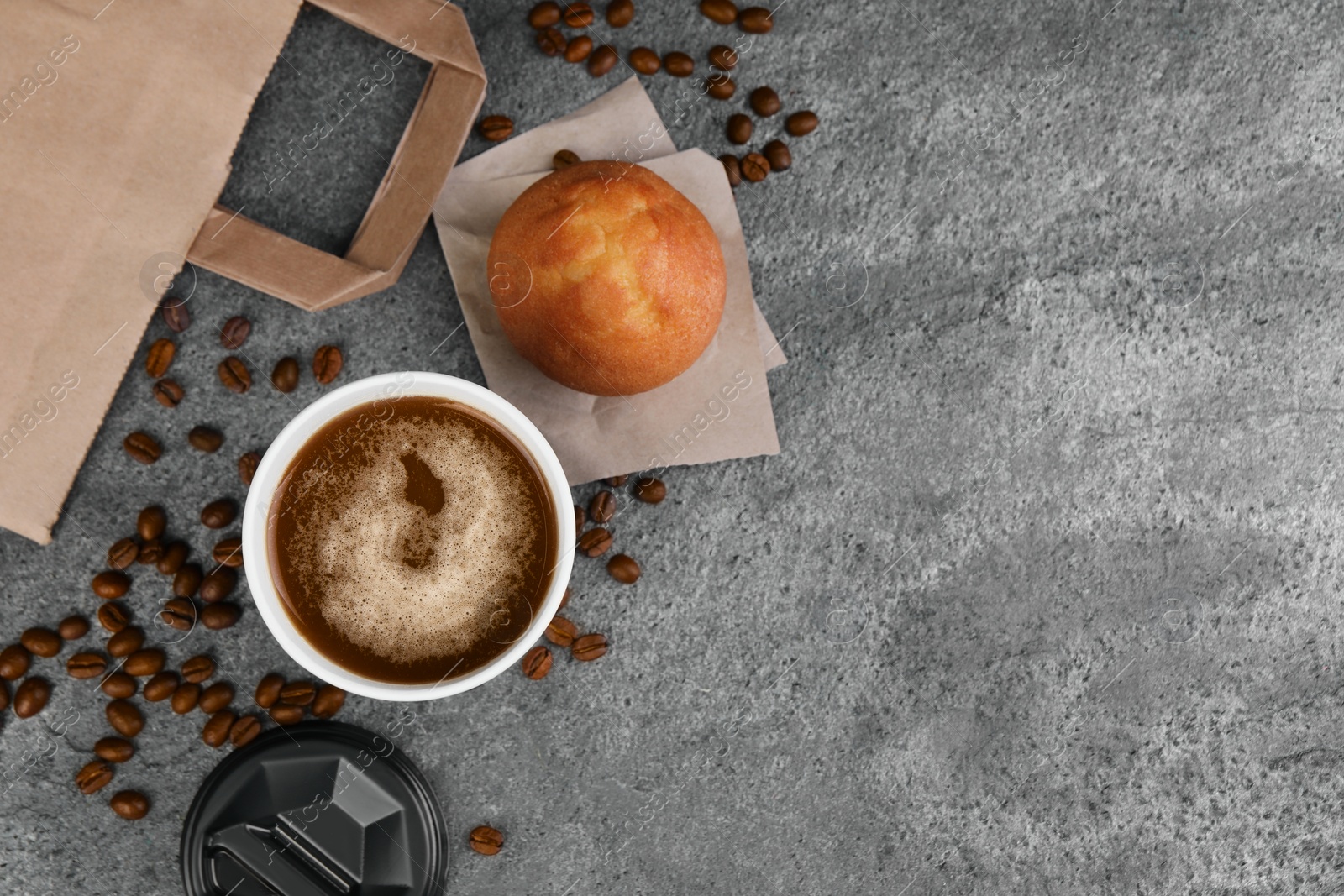 Photo of Coffee to go. Paper cup of tasty drink, muffin and beans on grey table, flat lay with space for text