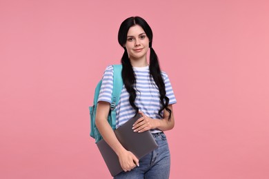 Photo of Cute student with laptop on pink background