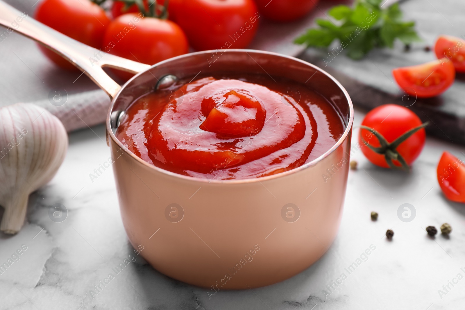 Photo of Delicious fresh tomato sauce on marble table, closeup