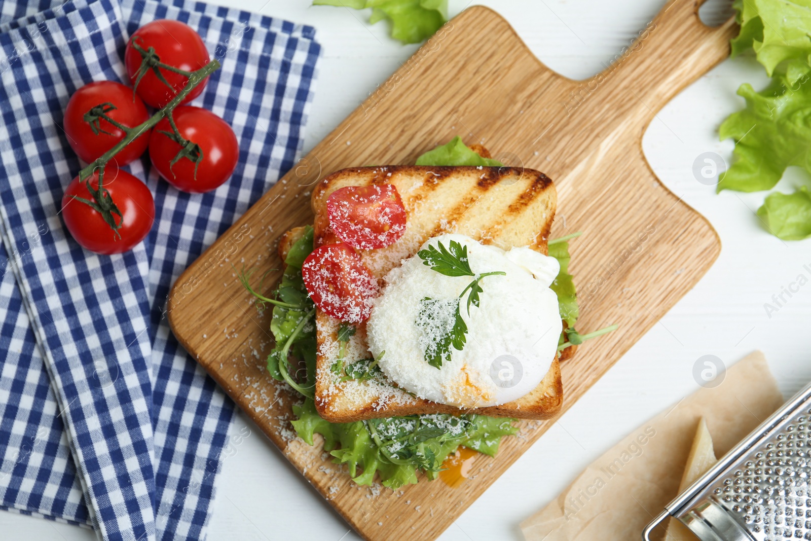 Photo of Delicious poached egg sandwich served on white wooden table, flat lay