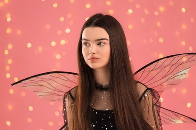 Beautiful girl in fairy costume with wings on pink background