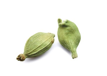 Photo of Dry green cardamom pods on white background, closeup
