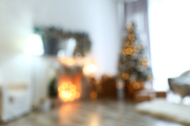 Photo of Blurred view of stylish interior with decorated Christmas tree and fireplace