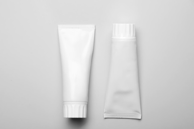 Photo of Blank tubes of toothpaste on white background, top view