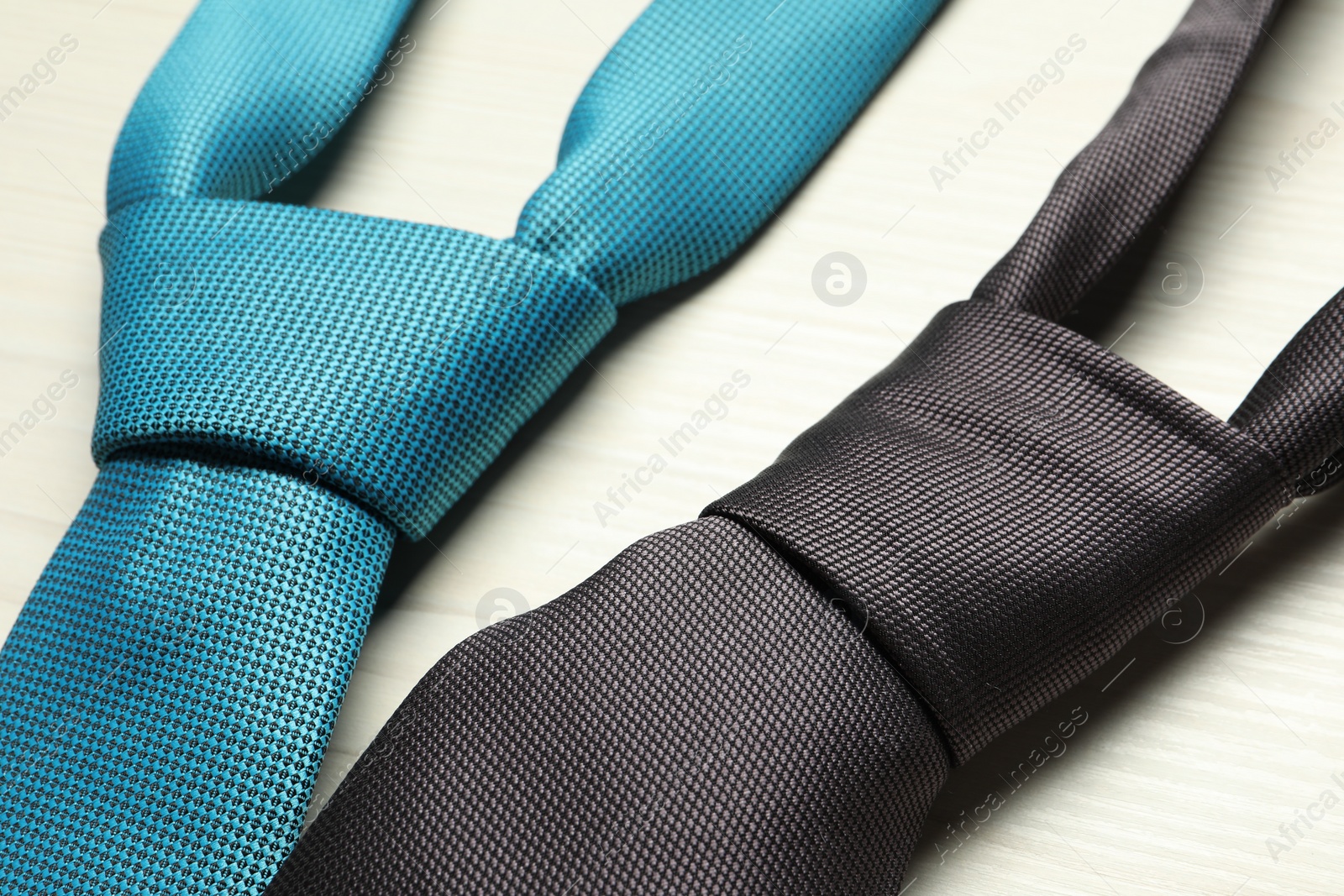 Photo of Two neckties on white wooden table, closeup