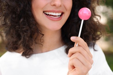 Photo of Woman with tasty lollipop outdoors, closeup view