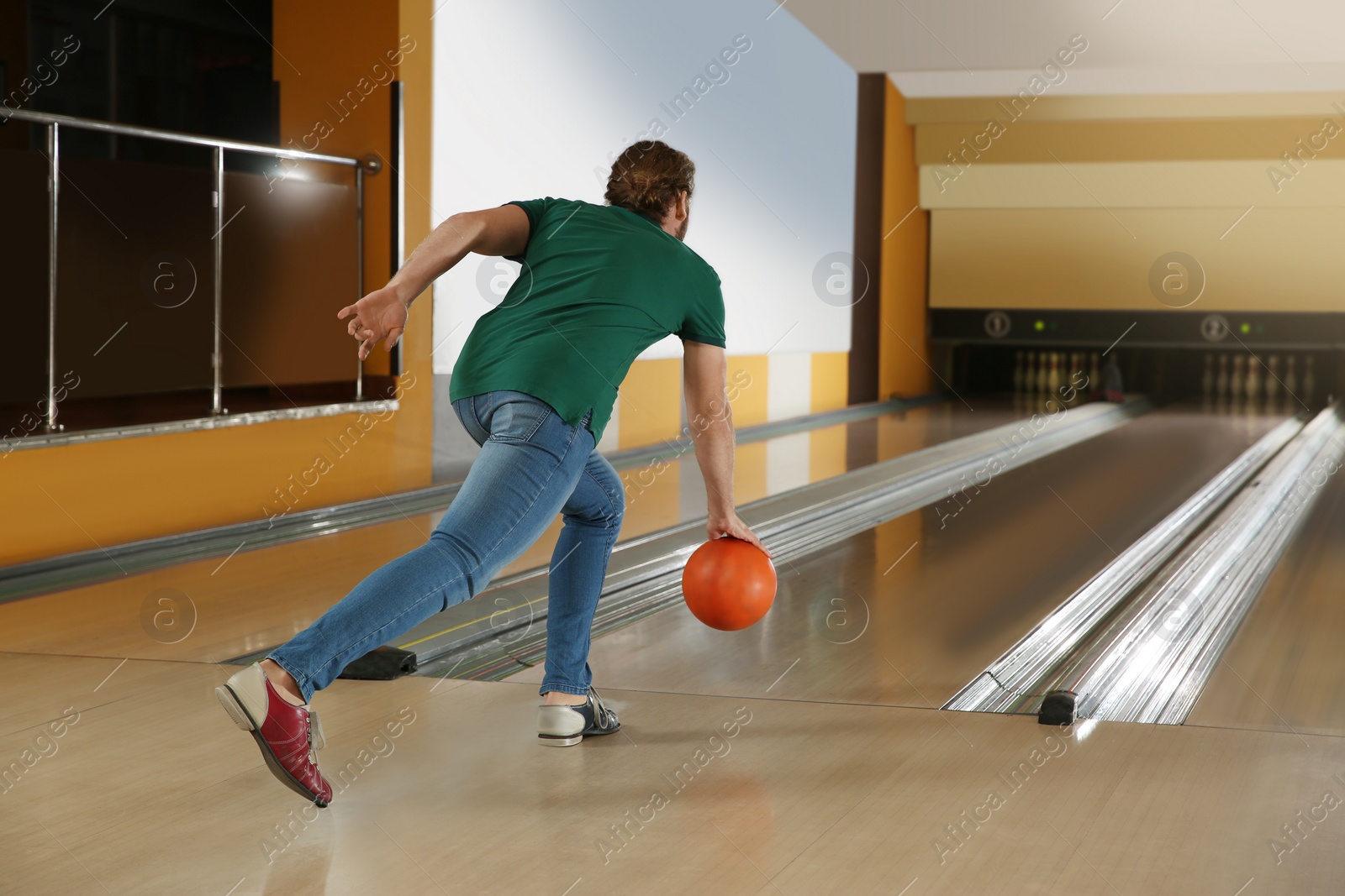 Photo of Young man throwing ball in bowling club