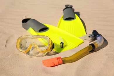 Pair of flippers, snorkel and diving mask on sandy beach