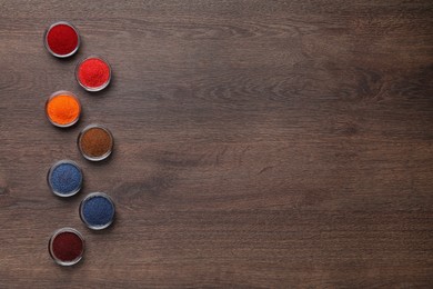 Many different food coloring on wooden table, flat lay. Space for text