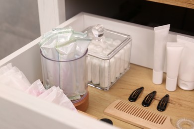 Photo of Open cabinet drawer with tampons and feminine hygiene products, closeup